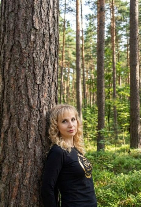 Mgr. Hanka Ajasta, vztahová alchymistka, opírá se o borovici v lese — autorka metody Hluboké odpuštění.