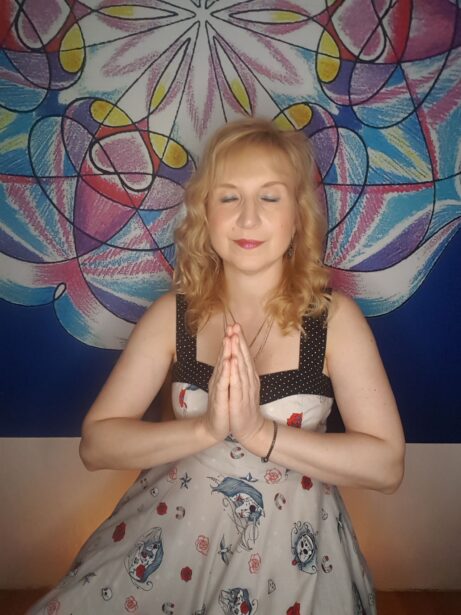 Mgr. Ajasta, vztahová alchymistka, v meditaci s rukama složenýma v gestu vděčnosti před barevnou mandalou — symbol vcítění a návratu k sobě jako prvního kroku ke změně vztahu.